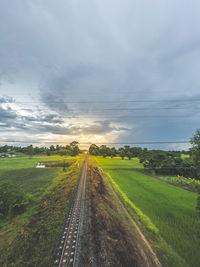 Dirt road passing through landscape against sky
