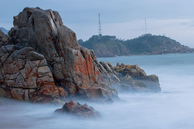 Rock formations in sea against sky