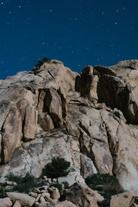 Low angle view of rock formation against sky at night