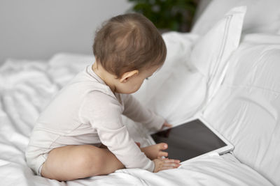 Boy using laptop while lying on bed at home