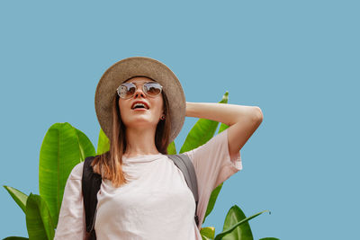 Portrait of young woman against clear blue background