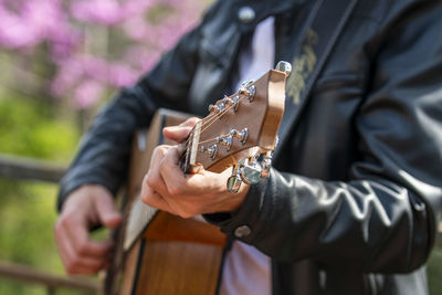 Midsection of man playing guitar