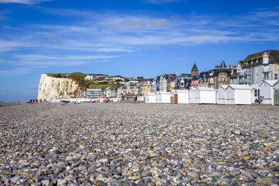 Houses on beach against sky in town