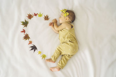 High angle view of child lying on bed