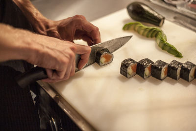 Midsection of person preparing food on cutting board