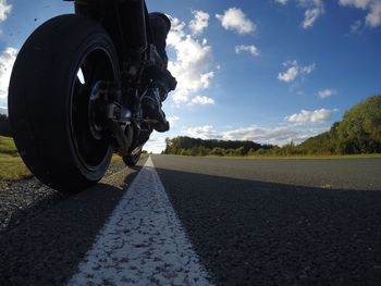 Low angle view of man with motorcycle on road