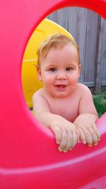 Portrait of cute baby by outdoor play equipment at playground