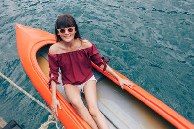 High angle portrait of smiling woman sitting on boat
