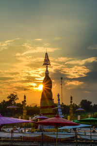 Temple against building during sunset