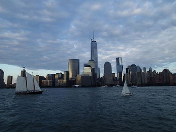 View of buildings in sea against cloudy sky