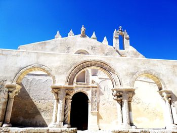 Low angle view of historical building against clear blue sky