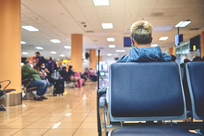 Empty chairs in the departure hall of the airport. unrecognizable people blurred.