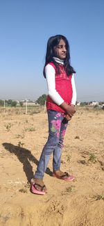 Full length portrait of girl standing on land