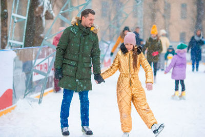 Rear view of people walking on snow