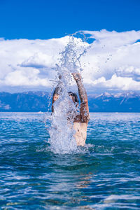 Man splashing in water while standing in sea