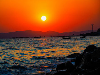 Scenic view of sea against orange sky