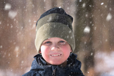 Portrait of a smiling boy in snow