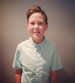 Portrait of boy standing against wall