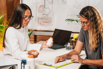 Nutritionist talking to a client, explaining dietary supplements