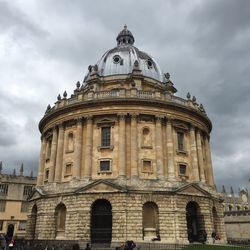 Low angle view of radcliffe camera against cloudy sky