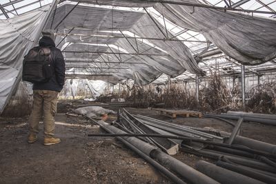 Rear view of man standing at abandoned factory