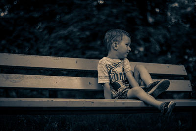 Rear view of boy looking at bench