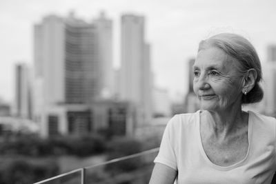 Portrait of woman against building in city