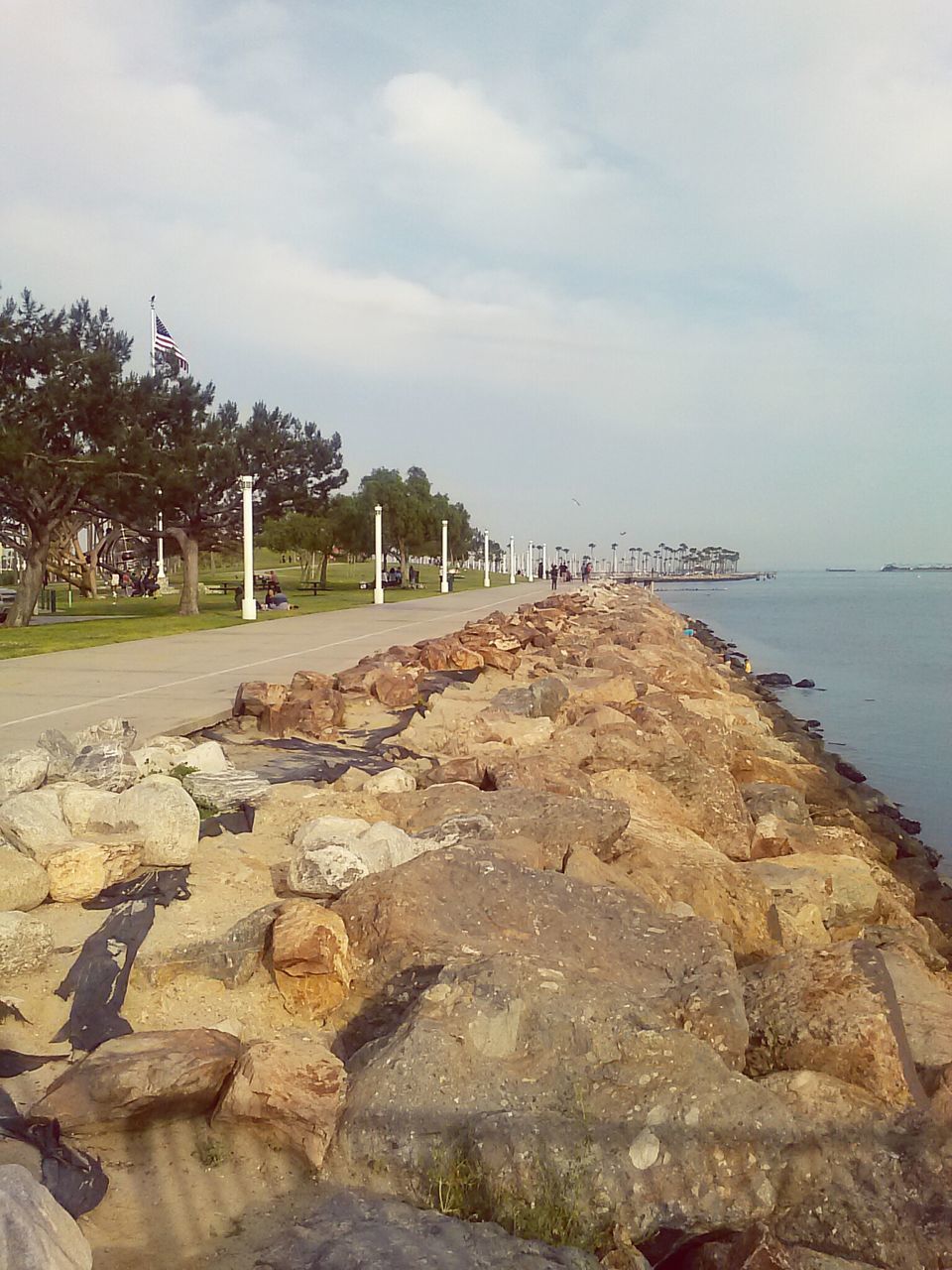 water, sea, sky, beach, tranquility, tranquil scene, cloud - sky, nature, scenics, shore, beauty in nature, rock - object, horizon over water, built structure, tree, cloud, pier, day, outdoors, cloudy