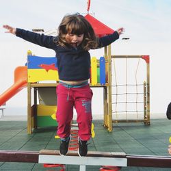 Full length of girl jumping at playground