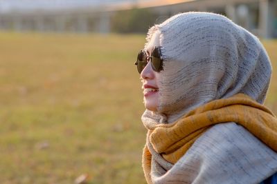 Side view of woman looking away on field