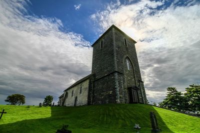 Low angle view of historic building against cloudy sky