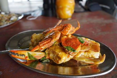 Crab with salted-egg sauce served in tin plate on the table