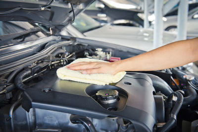 Hand cleaning car engine with a rag,worker
