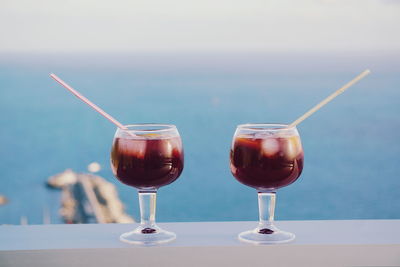 Close-up of wineglasses against sea