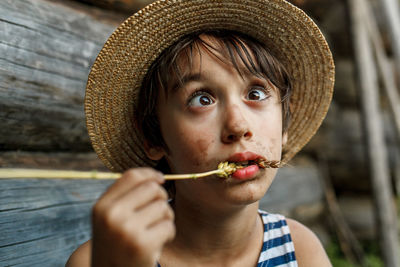 Close-up of cross eyed boy biting crop