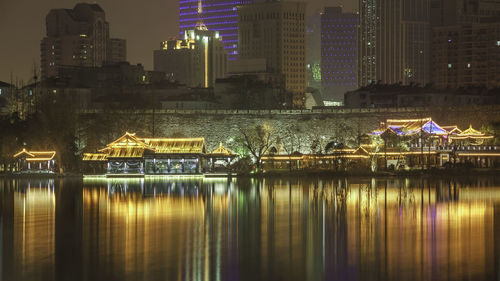 Reflection of illuminated buildings in river at night