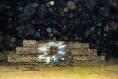 View of old ruin on field at night