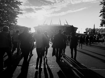 People walking on road in city against sky