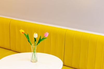 Close-up of yellow flower vase on table