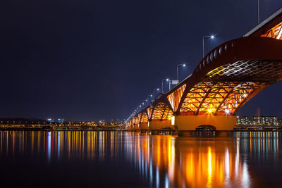 Illuminated seongsan bridge over han river against sky