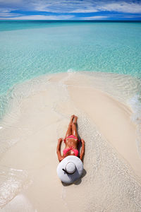 Woman lying on sand at beach