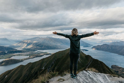 Full length of woman standing on mountain against sky