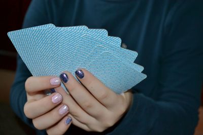 Midsection of woman holding cards