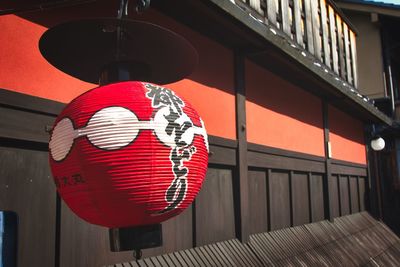 Low angle view of lanterns hanging by building