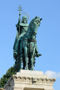 Low angle view of statue against blue sky