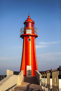 Low angle view of lighthouse against buildings