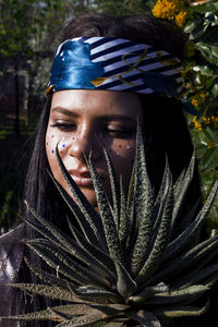 Close-up of young woman with succulent plant