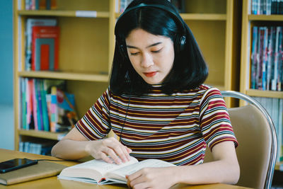 Young woman sitting on book