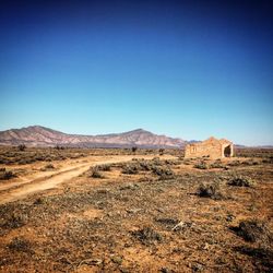 Scenic view of desert against clear blue sky