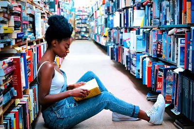 Young woman sitting on book